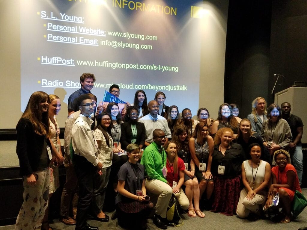 A group of people posing for a picture in front of a projector screen.