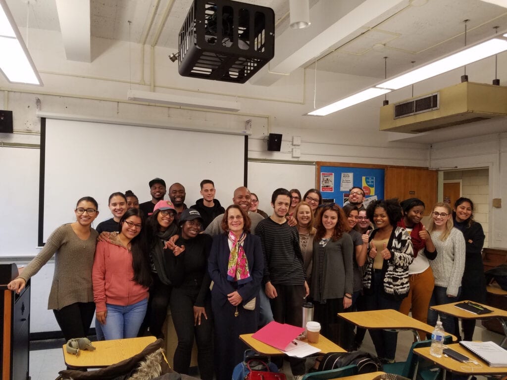 A group of people standing in front of a projector.