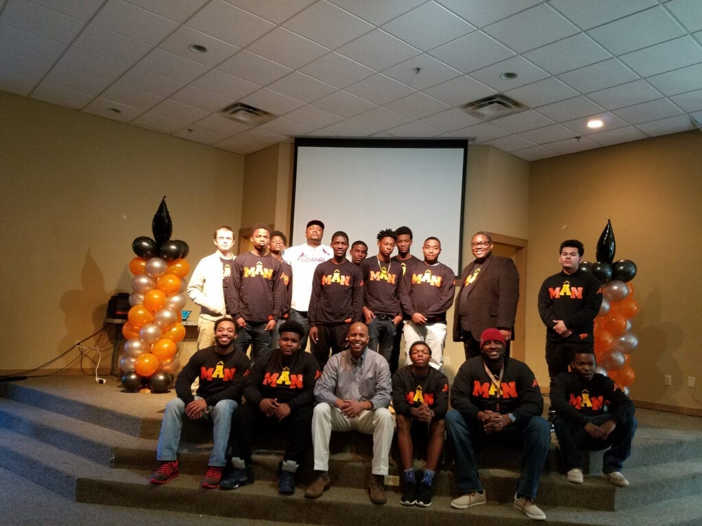 A group of people in front of an orange and white balloon.